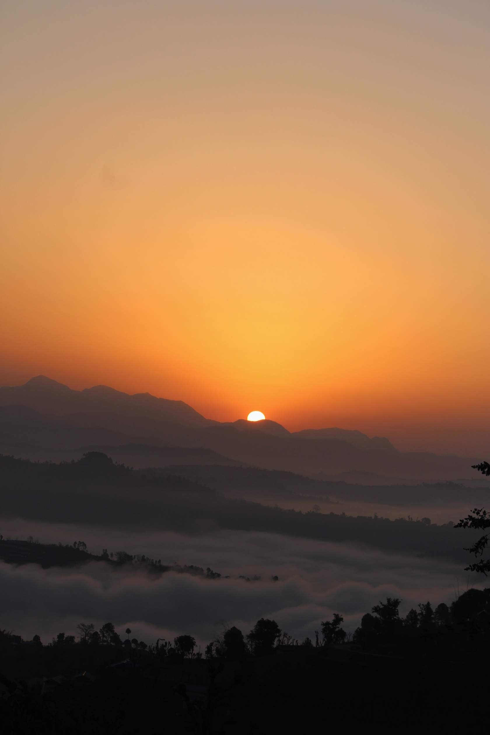 The sun rising above clouds