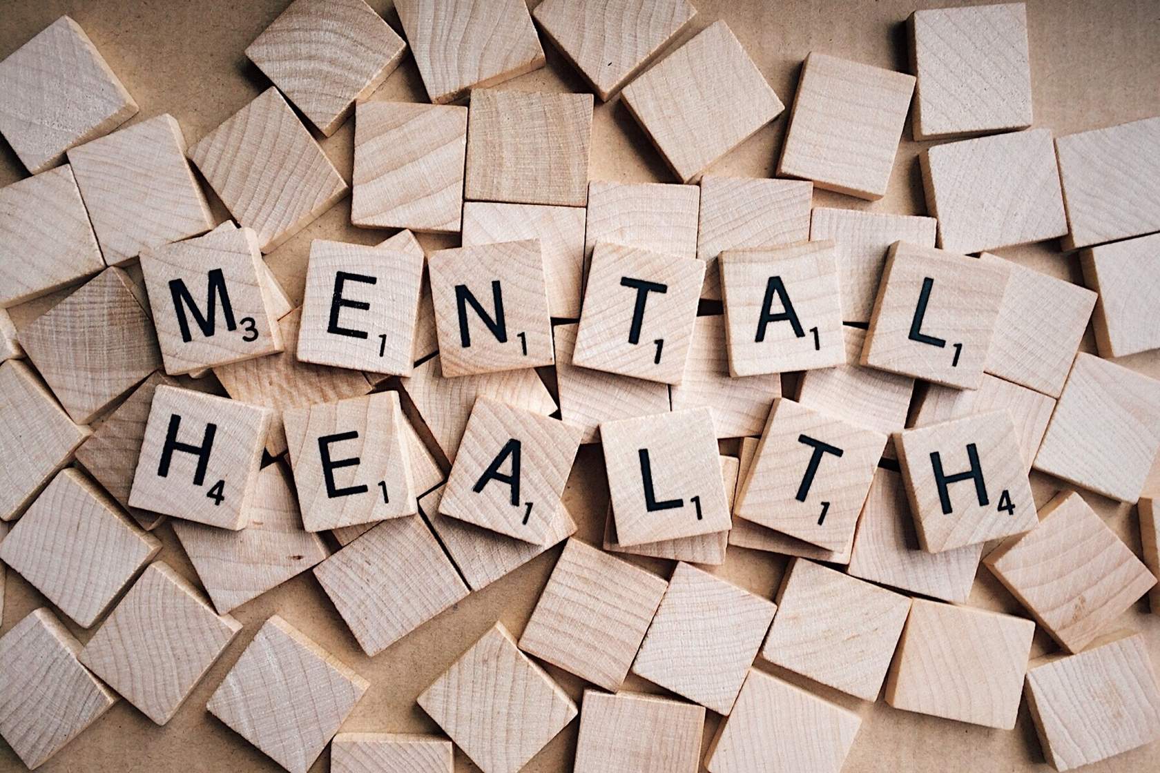 Image of a pile of tiles, with the words 'mental health' spelled out